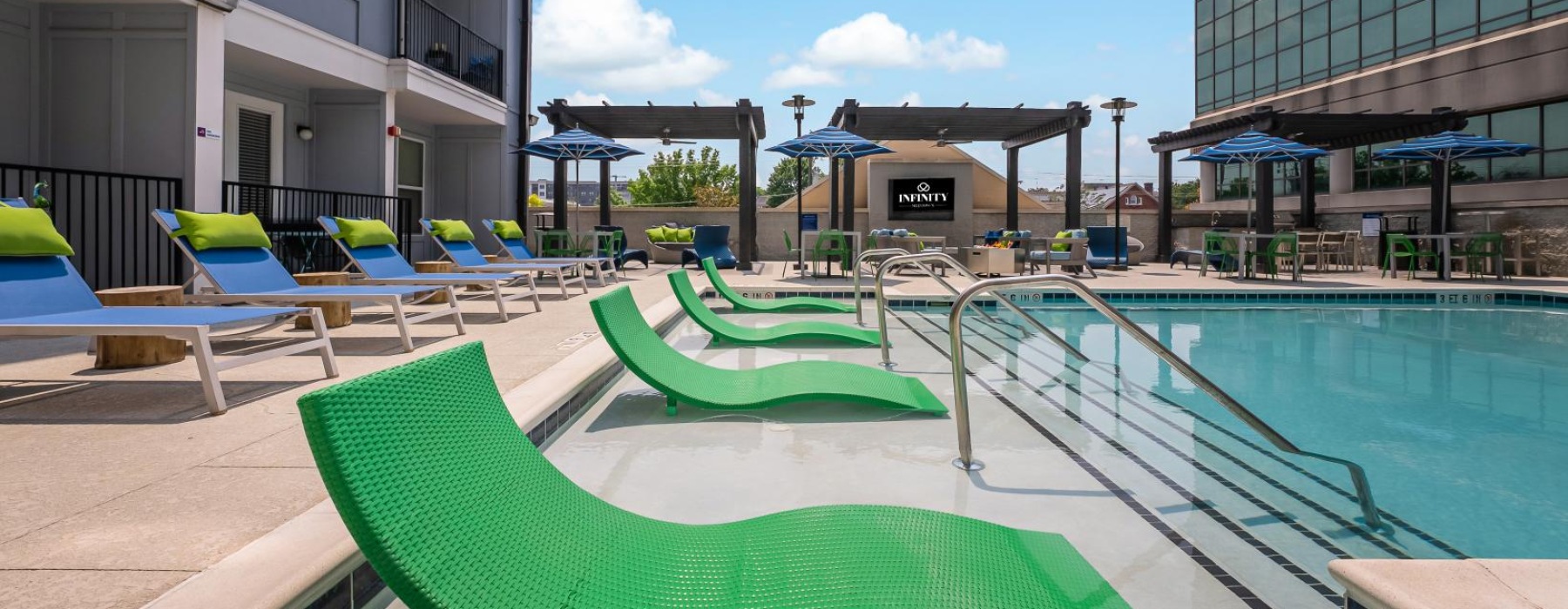 a pool with lounge chairs and tables by it