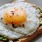 a breakfast sandwich with an egg on top