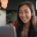 a woman smiling while working on laptop
